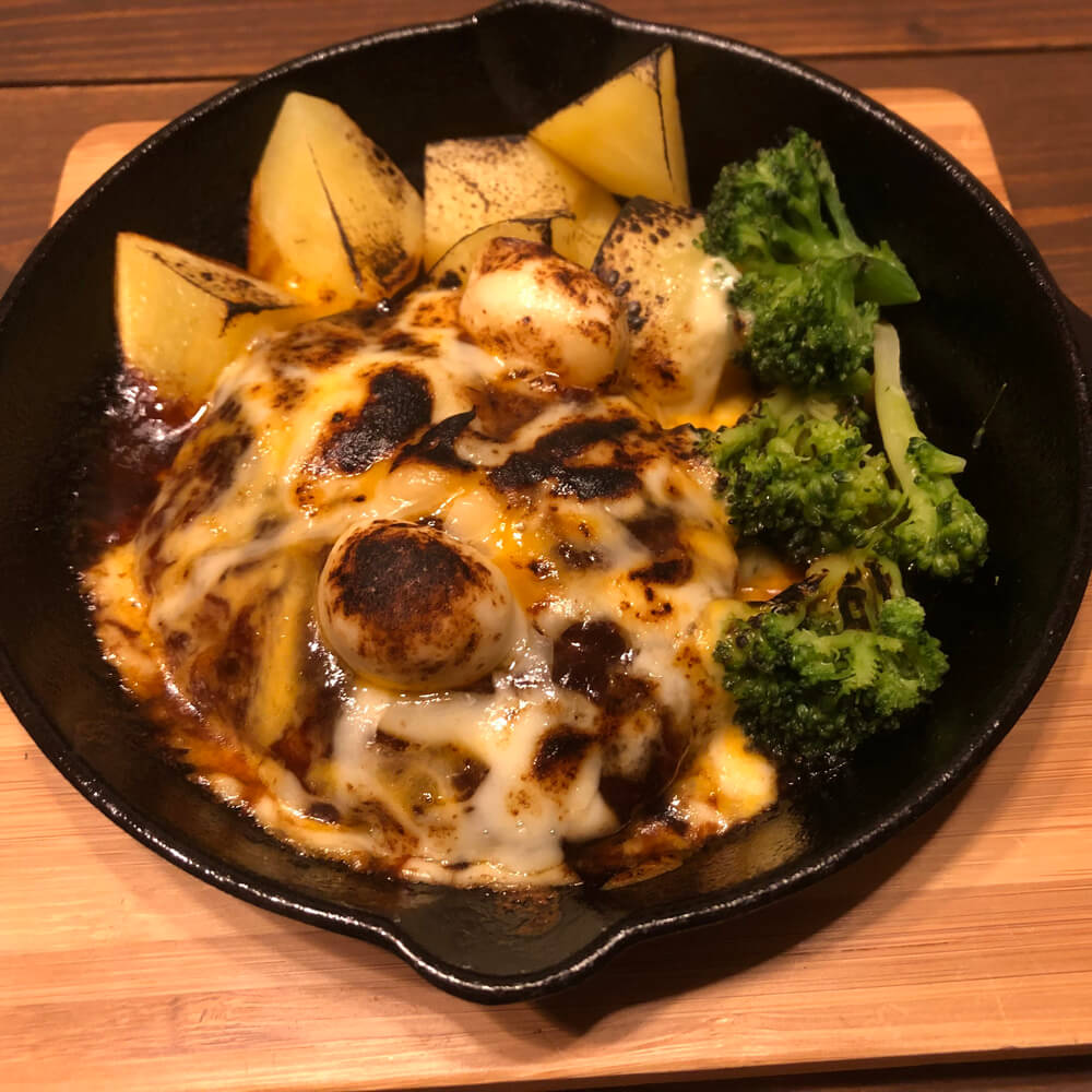 スキレットでチーズをのせて焼いたデミグラスハンバーグ